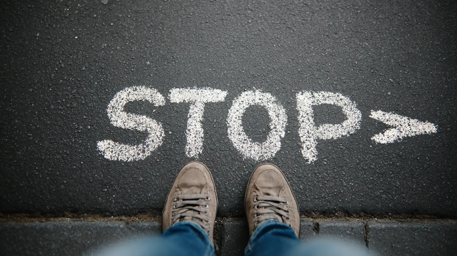 Voeten in wandelschoenen staan voor het woord 'STOP' geschreven in wit krijt op asfalt, symboliseert het stellen van persoonlijke grenzen
